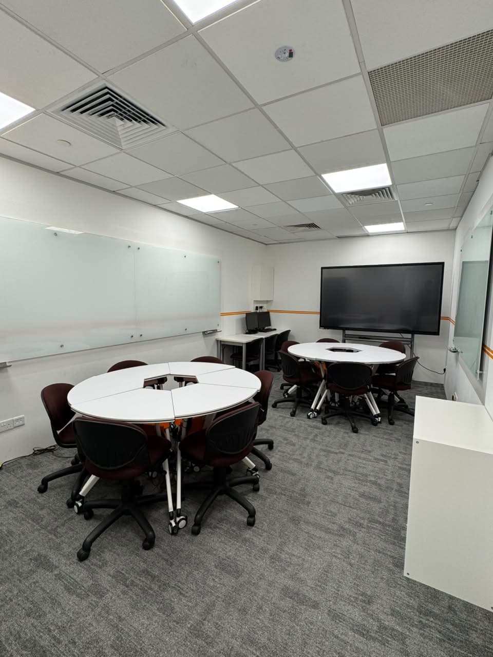 ITEL training room arranged with collaborative tables and a large display