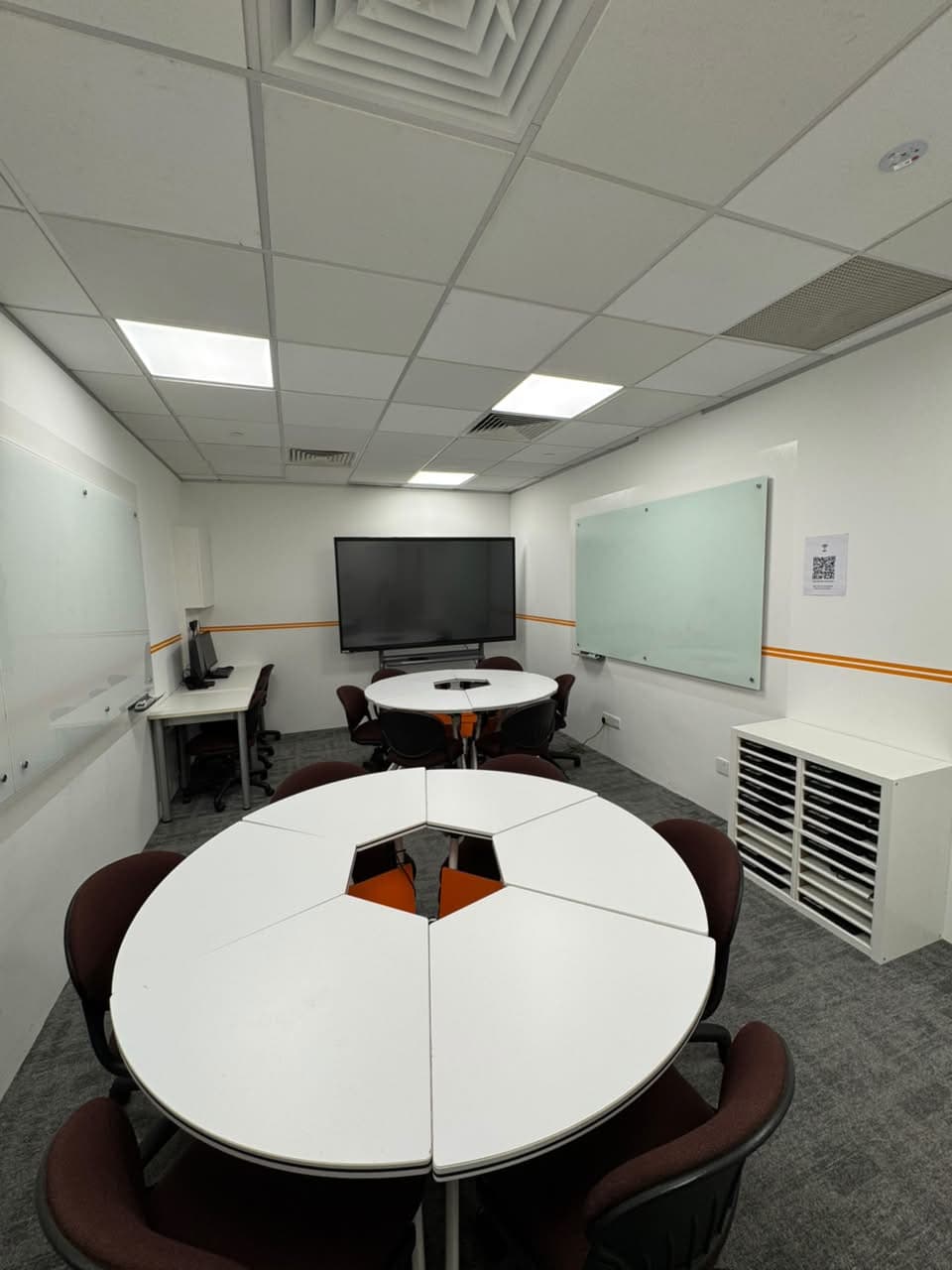 ITEL training room arranged with collaborative tables and a large display